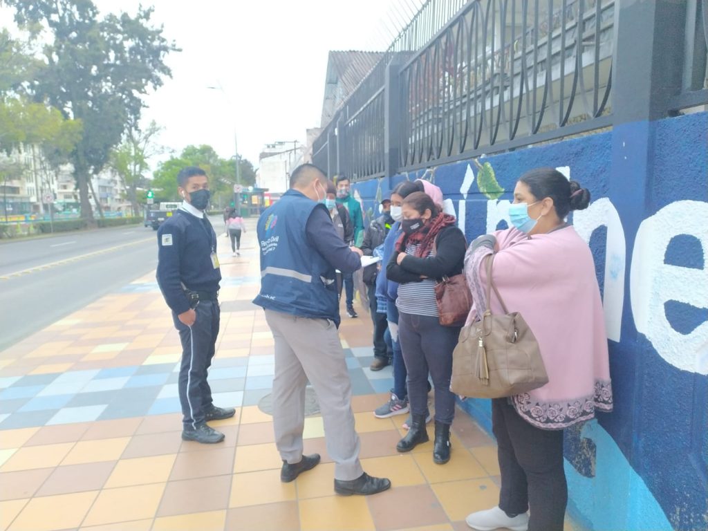 En los exteriores del Registro Civil de Loja, un funcionario entrega los turnos para que los usuarios realicen el pago del documento a tramitar.