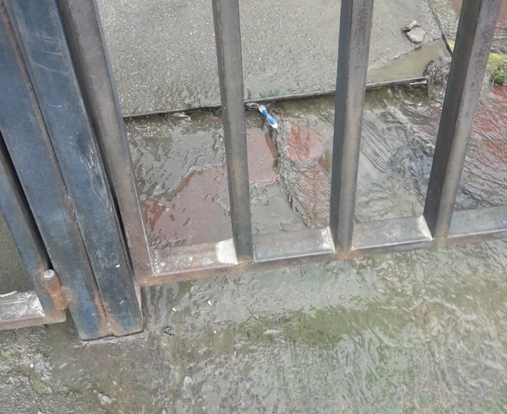 Las lluvias originan que el pozo de revisión del sector colapse y las aguas corran libremente por la calzada.
