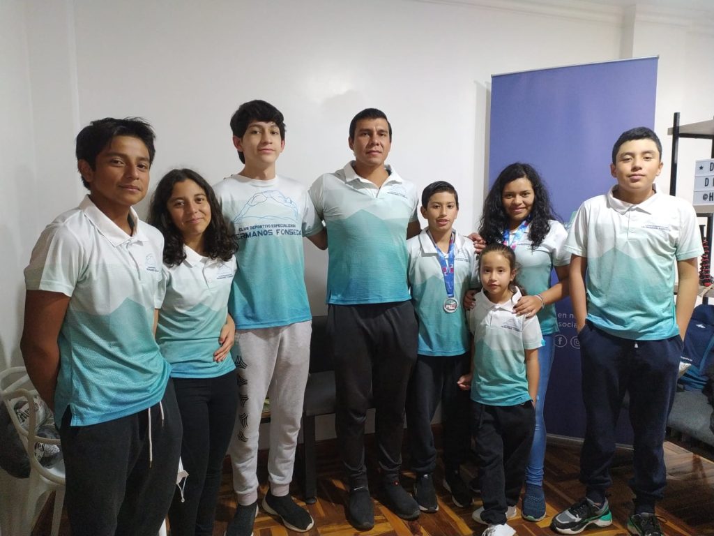 Los siete deportistas lojanos junto a su entrenador, Luis Fonseca Quintuña, durante su visita a HORA32.