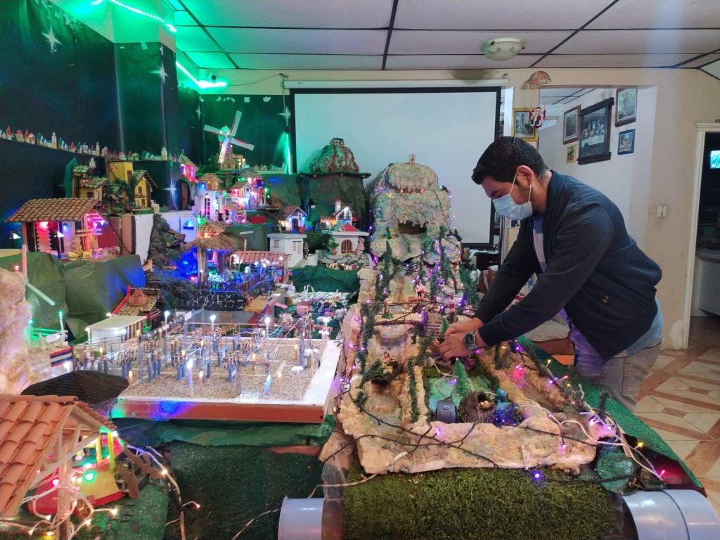 Augusto Álvarez Riofrío acomoda algunas de las piezas del pesebre que elaboraron en su hogar.