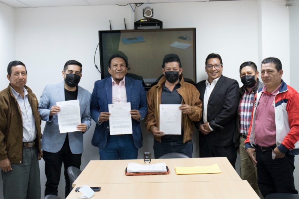 El alcalde, funcionarios municipales y dirigentes de los obreros tras la firma del documento.