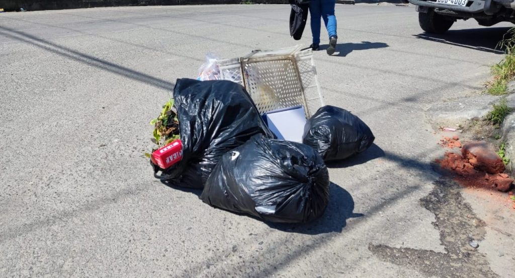 En estos últimos días recipientes de basura y fundas permanecen en la vía.