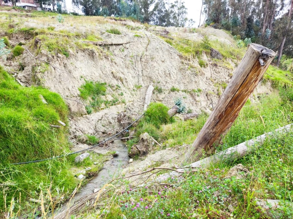 El afluente que corre contigua a Ciudad Alegría está lleno de maleza, piedras, rocas y palos.