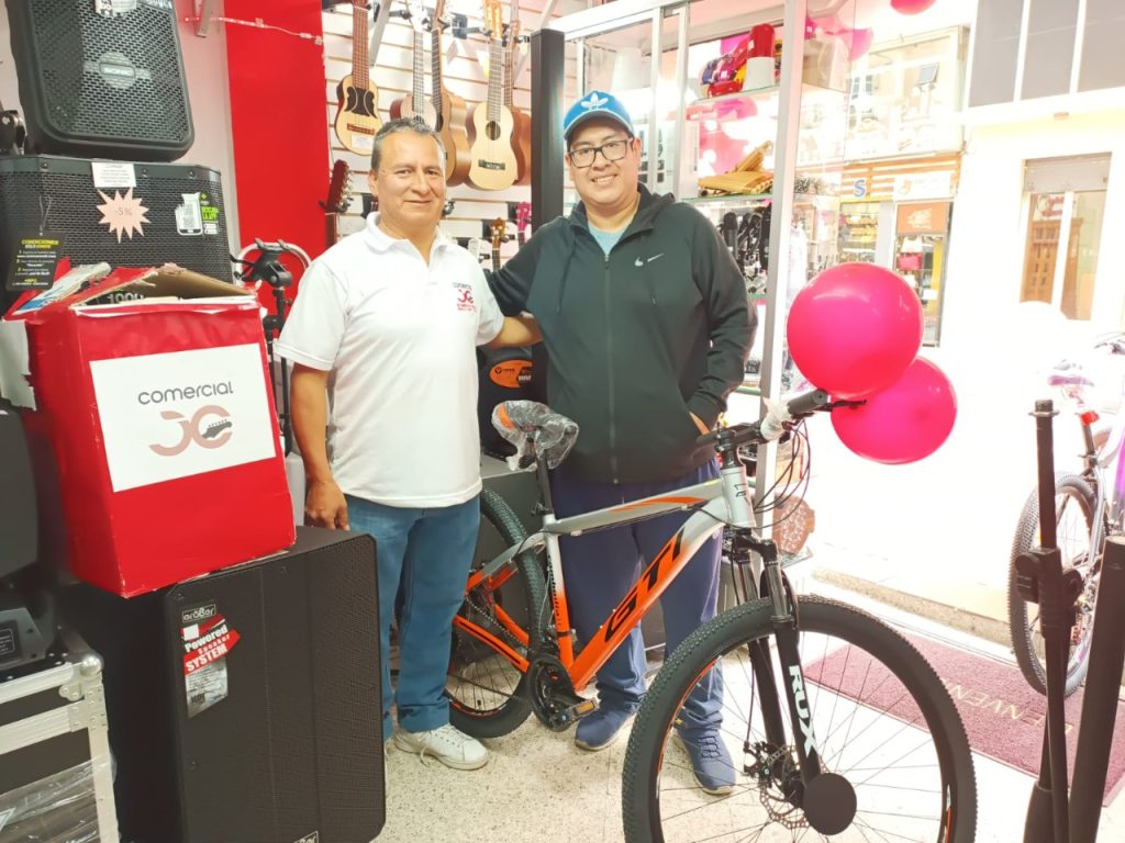 Jaime Coronel entrega la bicicleta al ganador, Ángel Montoya.
