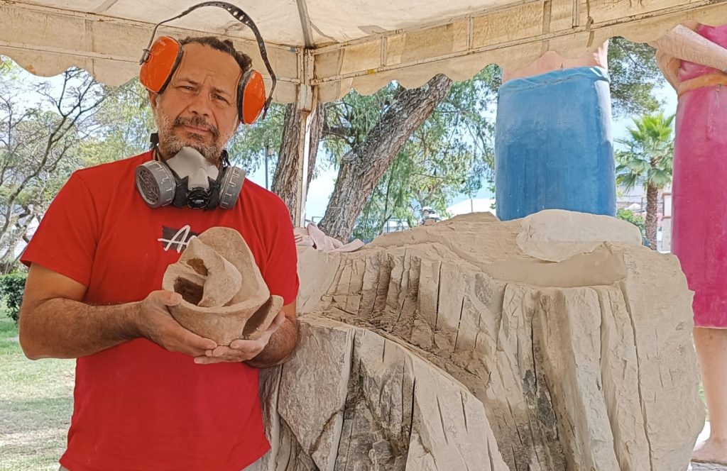 El artista Salvador, sostiene en sus manos la escultura finalizada, destacando su contribución en la octava edición del Festival Internacional de Artes Vivas de Loja.