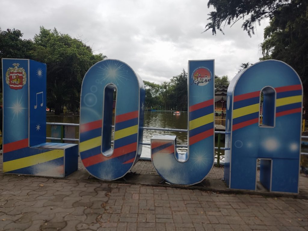 Un distintivo con el nombre de Loja, donde constan su escudo, los colores de su bandera y un logotipo que identifica al parque recreacional. También es usado para el registro de fotografías.    