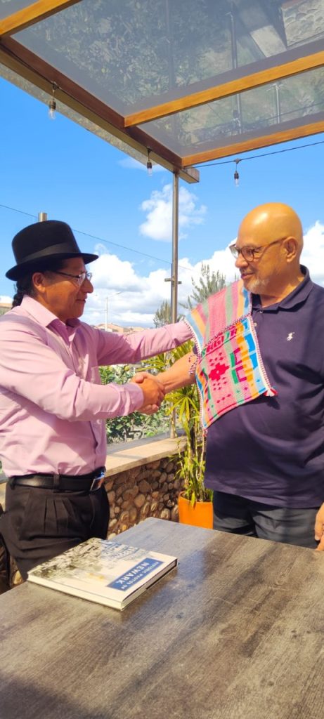 El alcalde de Saraguro, Abel Sarango, obsequia al concejal de Newark, Carlos González, una alforja, prenda típica del cantón.