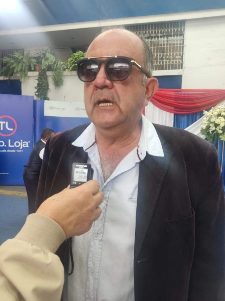 Milton Mena, exgerente de la Cooperativa Loja, porta un modelo a escala de lo que fueron las primeras unidades.