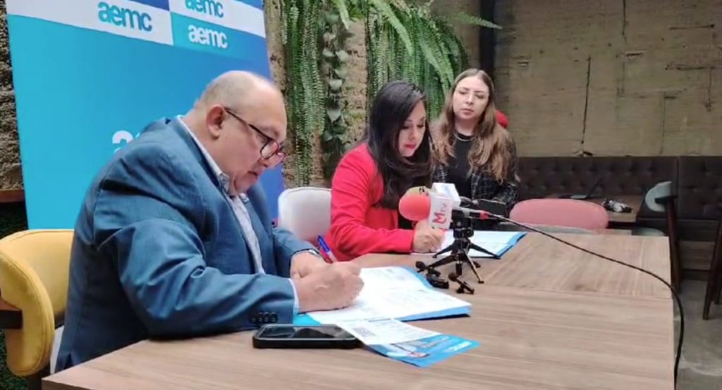 Sócrates Carrión, presidente de la Mesa Turística y Jenny Macas, directora de AEMC Loja, durante la firma del convenio.