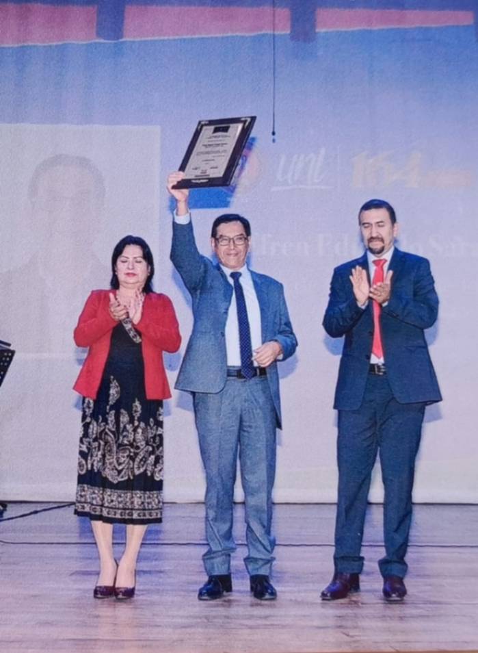 El rector de la UNL, Nikolay Aguirre Mendoza, y la vicerrectora, Elvia Zhapa Amay, entregan el galardón al intelectual, en el Teatro Bolívar.