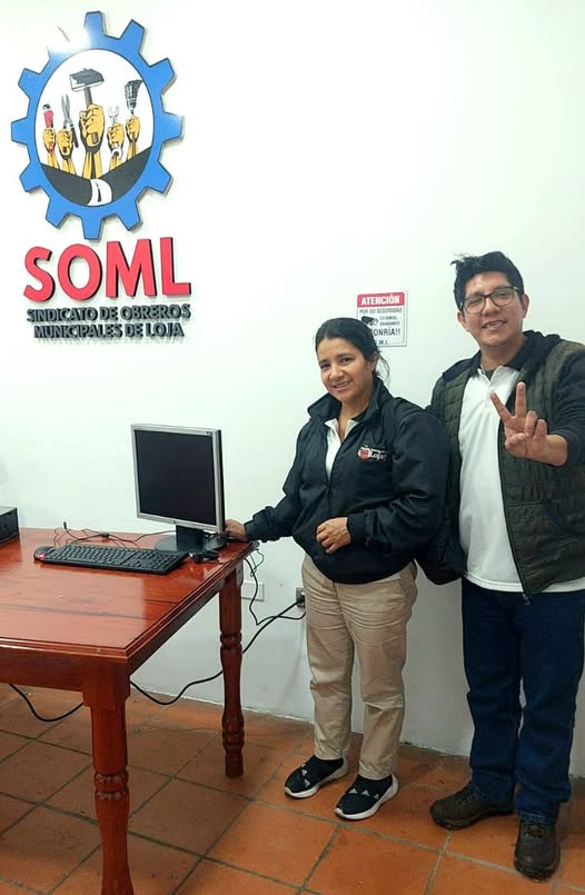 La beneficiaria recibe la computadora de manos de Hermes Vicente Tenesaca.