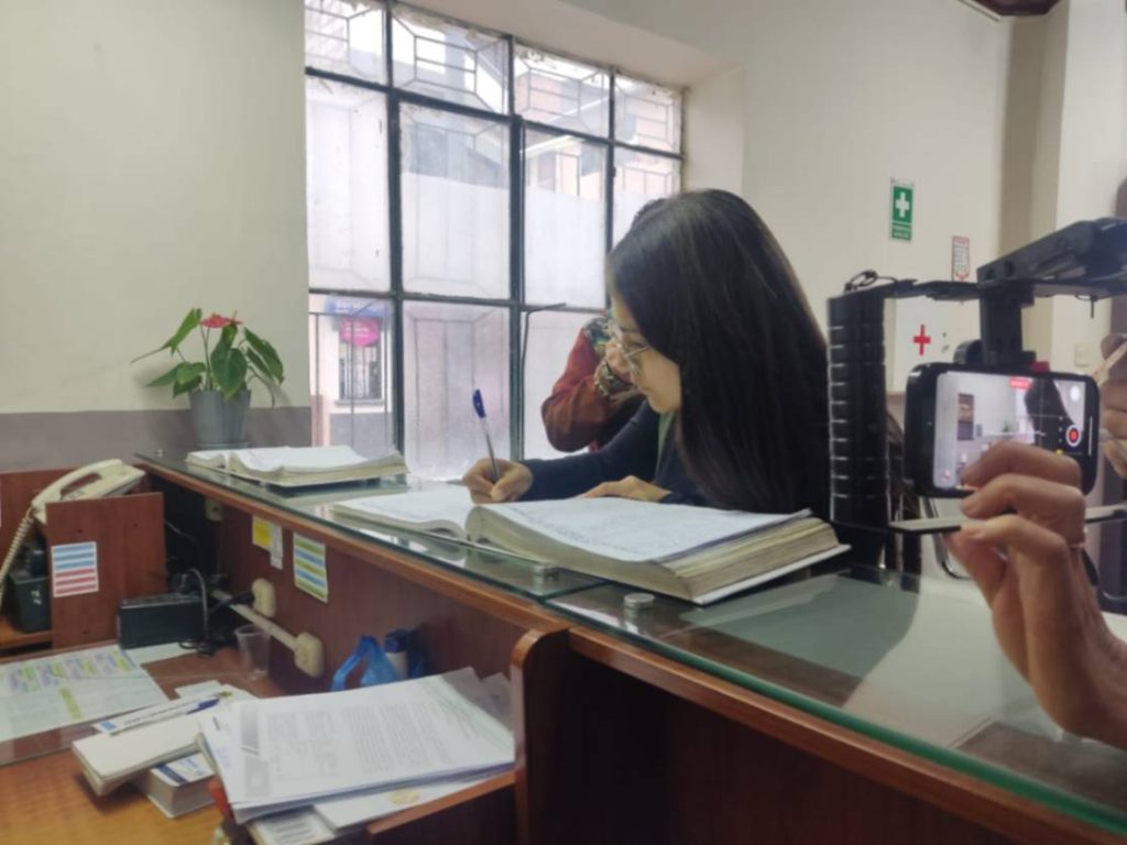 Diana Aguilar Villacrés, cerca de las 18:00 del último viernes, 19 de septiembre de 2025, firma el libro de registros para ingresar a la Comisaría de Ambiente y Minería.